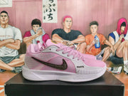 Side view of pink and light gray shoes with a dark patterned Swoosh and ROOTS lettering
