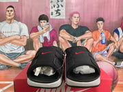 Front view of black Nike slides showing open toes, perforated uppers, and red Swoosh details.