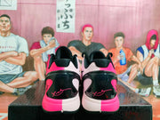 Rear view of pink, black, and white Nike basketball shoes placed on a box.