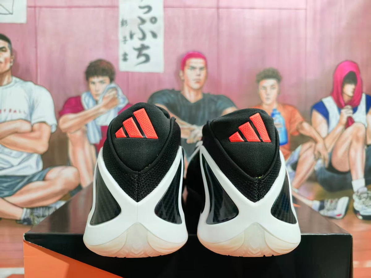 Rear view of black sneakers with white heel overlays and red Adidas tongue logos