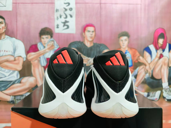 Rear view of black sneakers with white heel overlays and red Adidas tongue logos