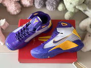Top-angle view of the pair showing the laces, padded collars, tongue details, and purple-gold color blocking.