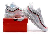 Nike Air Max 97 sneakers posed on and beside a red shoebox.