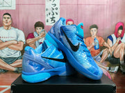Blue Nike basketball sneakers displayed on a shoebox, showing the textured upper, black Swoosh, and translucent outsole.