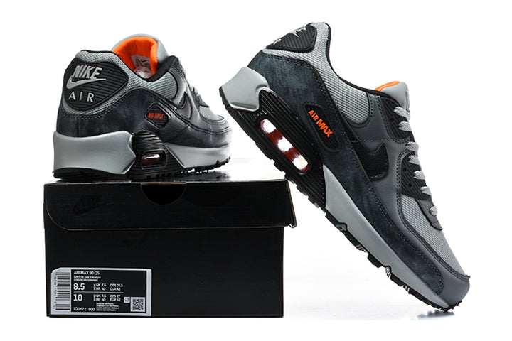 Grey and black Nike Air Max 90 sneakers shown from the rear and side, with a box label visible.