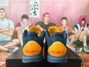 Heel view showing orange heel panels and signature-style graphics on navy basketball shoes
