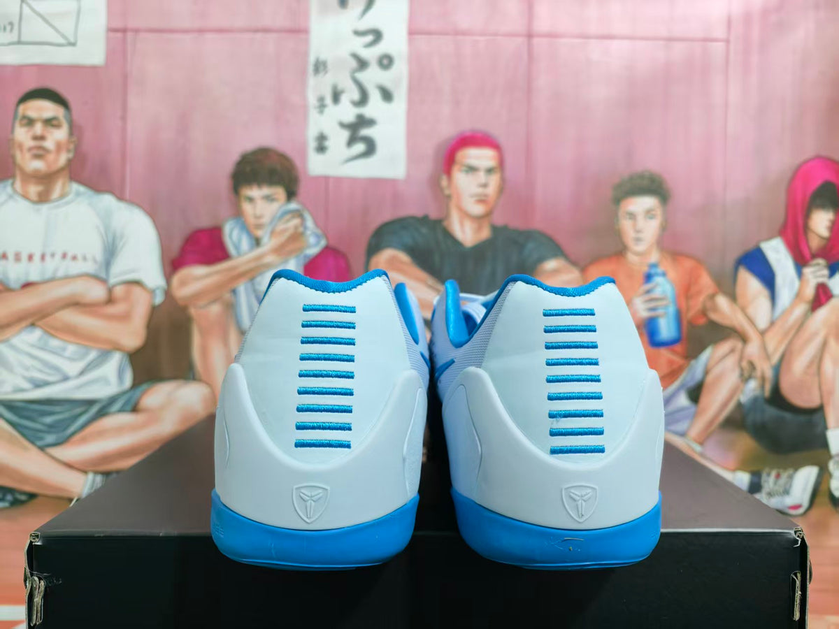 Rear view of light blue and white basketball sneakers with blue heel accents and a visible heel emblem.