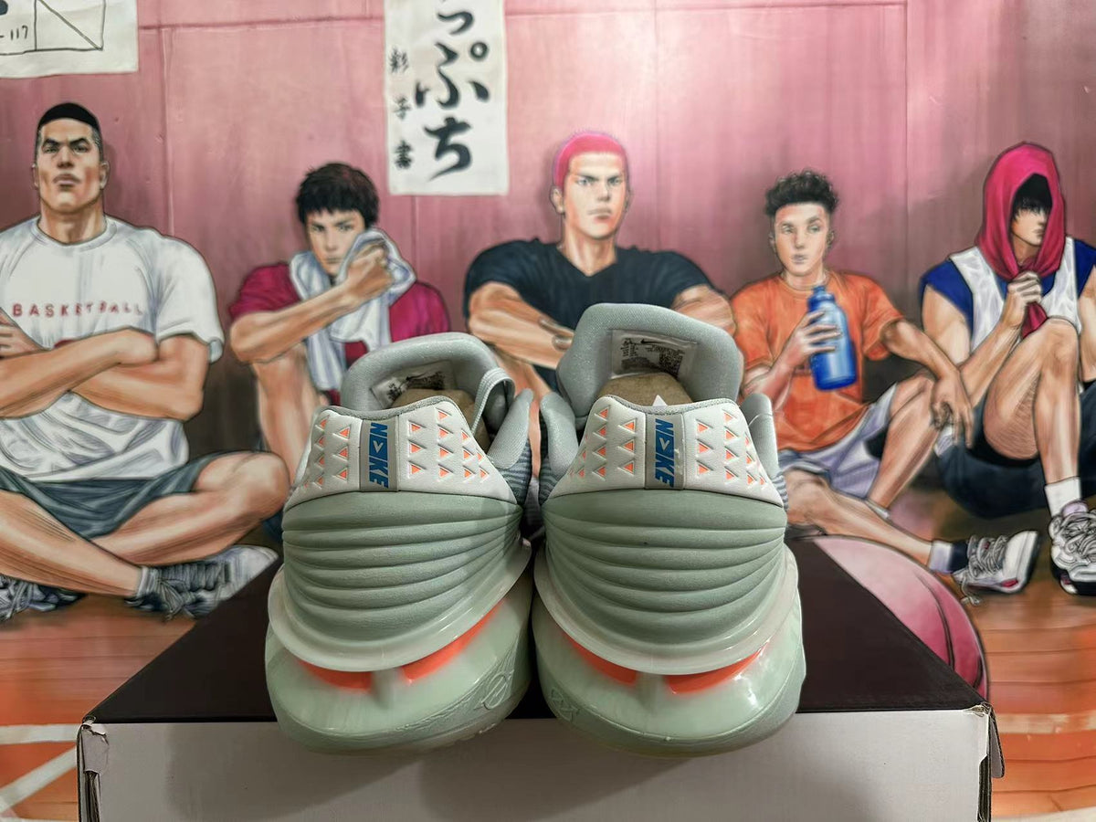 Rear view of gray and blue Nike basketball sneakers with coral heel details