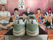 Rear view of gray and blue Nike basketball sneakers with coral heel details