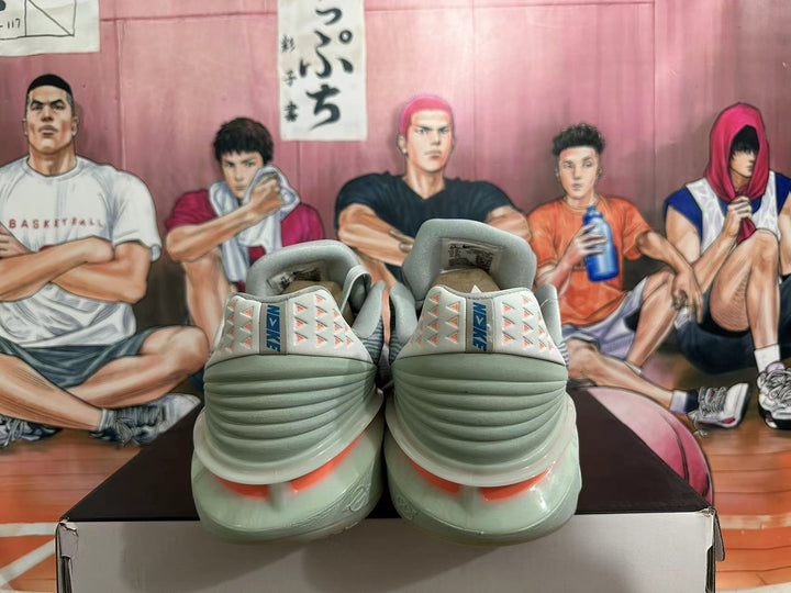 Rear view of gray and blue Nike basketball sneakers with coral heel details
