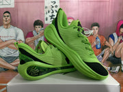 Angled view of two green basketball sneakers highlighting the textured uppers, black accents, and translucent outsole sections.