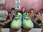 Front view of Nike basketball sneakers showing bright green tongues, gray laces, pink trim, and textured toe panels.