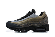 Side profile of a Nike Air Max 95 TT sneaker with tan patterned panels and black sole.
