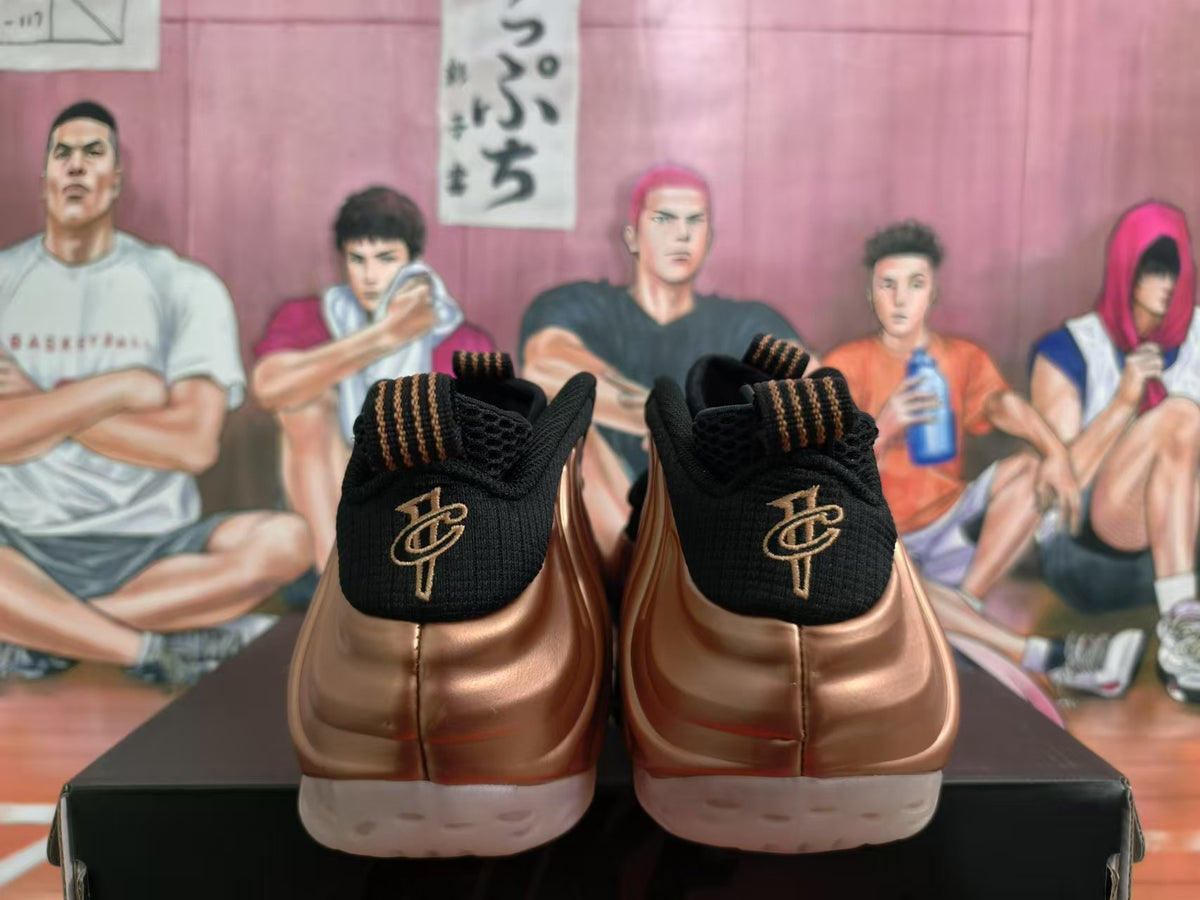 Rear view of rose-gold and black Nike sneakers showing black heels, gold-toned heel emblems, and light outsoles.