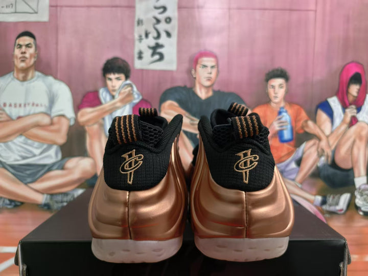 Rear view of rose-gold and black Nike sneakers showing black heels, gold-toned heel emblems, and light outsoles.