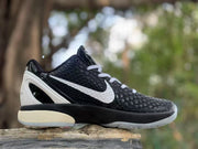 Outer side profile of a black sneaker with a white Swoosh, textured upper, and translucent outsole.