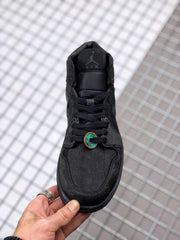 Top-down view of the black sneaker showing the laces, tongue, and patterned toe box.