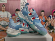 Angled view of the blue sneaker pair displaying the textured upper, padded collar, side detailing, and translucent outsole.