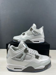 Angled close view of the grey Jordan Air Jordan 4 pair, highlighting the lace system, mesh panels and layered midsole.
