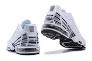 Rear and outsole views of white Nike Air Max Plus sneakers with black details and visible cushioning.