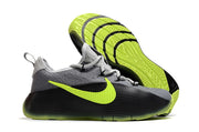Smoke grey and black sneaker pair highlighting the neon patterned outsoles.