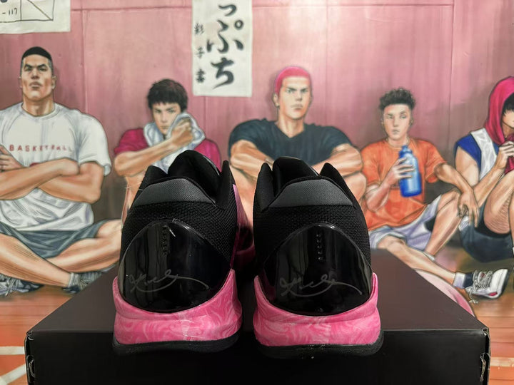 Rear view of black basketball shoes with pink marbled sole accents