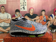 Side view of a gray Nike basketball shoe with an orange Swoosh and visible Air Zoom sole marking.