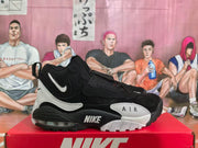 Side view showing the black and white layered upper, ankle strap, Nike branding, AIR lettering, and visible heel cushioning unit.