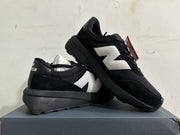 Pair of black New Balance U370 sneakers shown at an angle, highlighting the chunky soles.