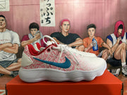 Side view of a white Nike shoe with pink rose-style panels and a blue Swoosh.