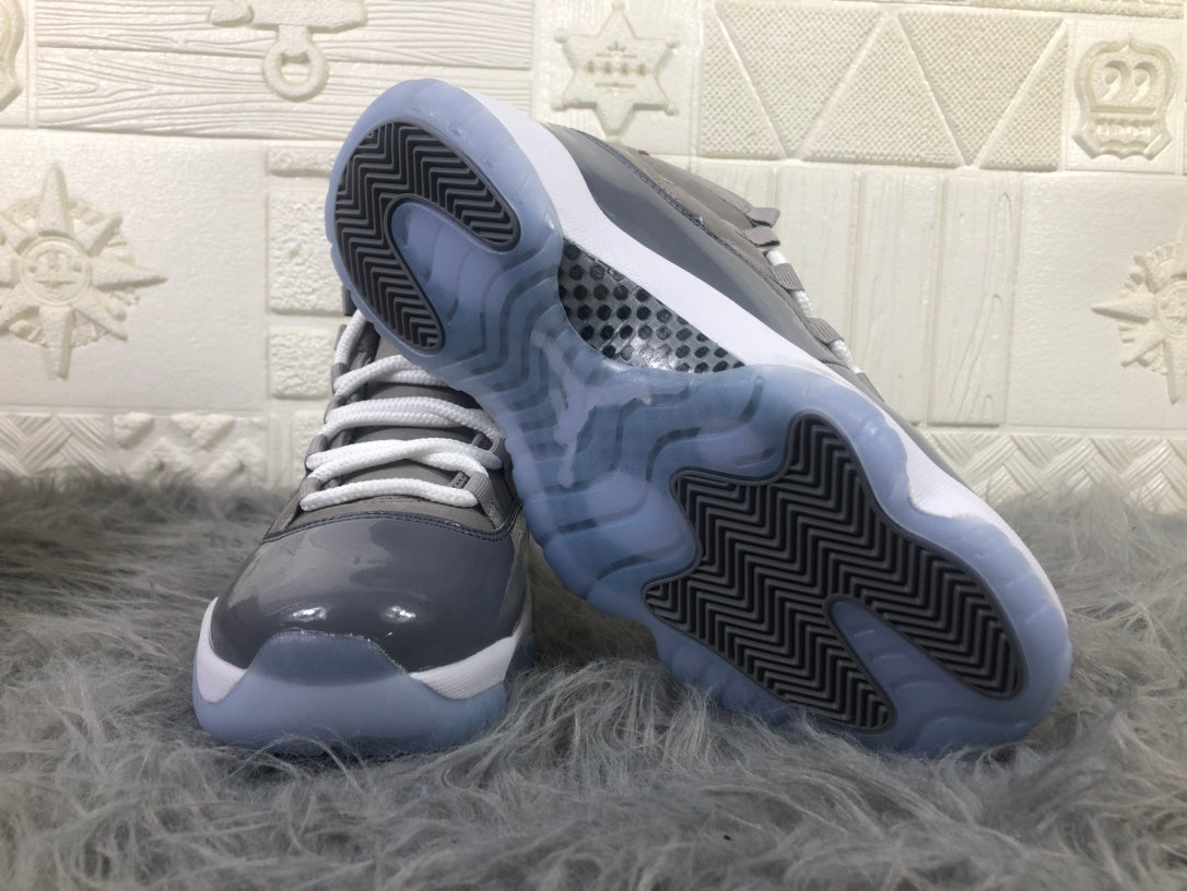 Air Jordan 11 high-top sneakers shown from the front and outsole, with a cool grey upper and translucent soles.