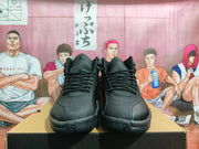 Front view of a pair of black high-top sneakers showing the laces, tongue logos, toe panels, and textured forefoot.