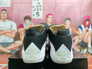 Rear view showing speckled heel panels on black and white Jordan basketball shoes
