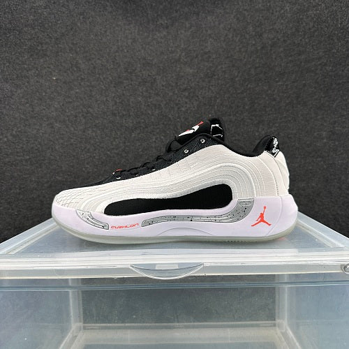 Side view of a white, black, and red Jordan low-top basketball shoe.