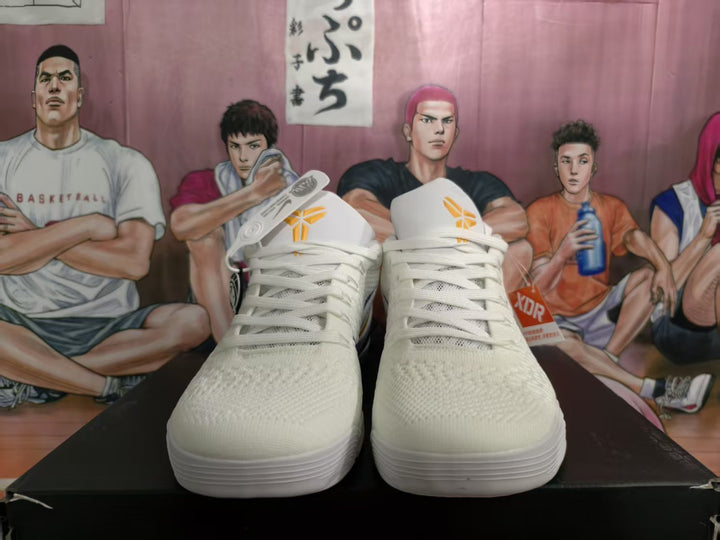Front view of white Nike basketball sneakers with yellow tongue logos and a purple-and-yellow color scheme visible at the sides.