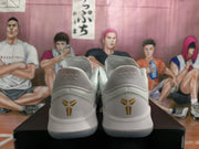 Rear view of the pair showing gold Kobe emblems on the heel panels and light-colored padded collars.