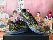 Angled view of the black and gold basketball shoes and translucent outsole