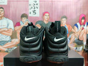 Rear view of black Nike Foamposite-style high-top sneakers with white heel Swooshes