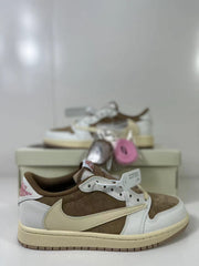 Close side view of the sneaker showing the brown textured central panel, white leather-like overlays, cream Swoosh, and pink heel detail.