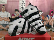 Angled view of the paired black and white Nike sneakers highlighting the high-top construction and side lettering.
