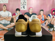 Rear view of white Nike Kobe basketball shoes with gold heel panels and black-and-white sole detailing