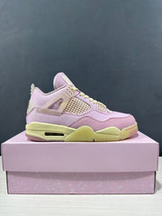 Side view of pink Jordan Air Jordan 4 Retro sneakers with pale yellow accents displayed on a pink shoebox.