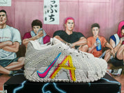 Pair of light pink Nike basketball shoes showing colorful side graphics and sculpted outsoles.