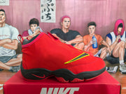 Side profile of a red and black Nike high-top sneaker showing the raised collar, side accent, and layered outsole.