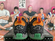 Rear view of black graphic basketball sneakers with orange collars, green heel sections, and KD branding.