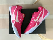 Top-down view of the pink sneakers arranged over a black shoe box.