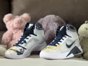 Front three-quarter view of the shoes with patterned gold toe panels.