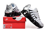 White, silver, and black Nike Shox TL sneakers displayed with a red Nike shoe box; the box label shows sample sizes.