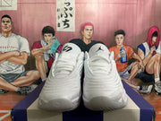 Front view of white and grey Jordan basketball sneakers with layered laces and perforated toe areas.