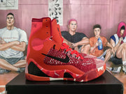 Side view of a red high-top basketball sneaker showing the black Nike Swoosh, textured upper, red overlays, and patterned midsole.